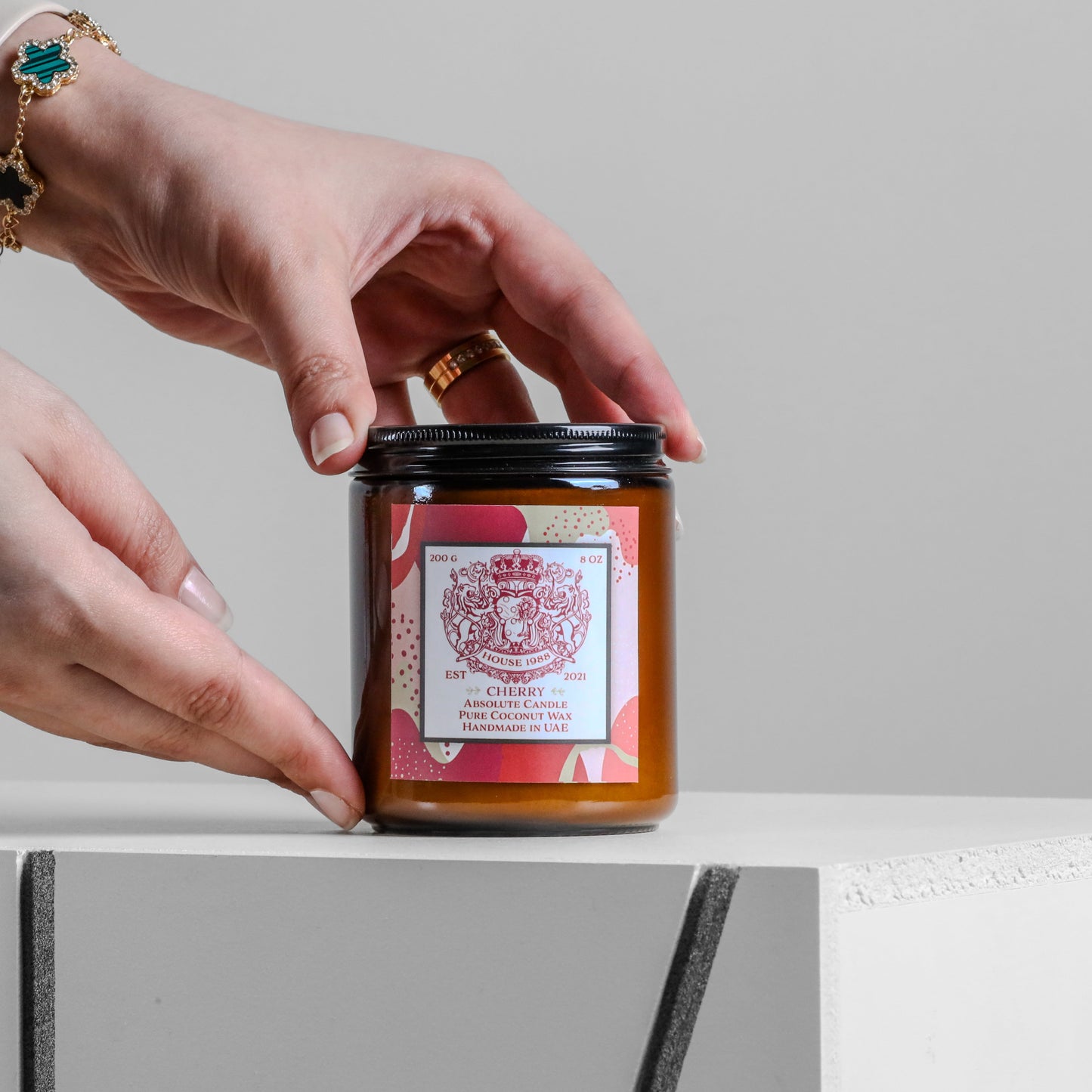 Pyramid of House 1988 scented candles in amber jars with gold lids, crown lid and one open jar