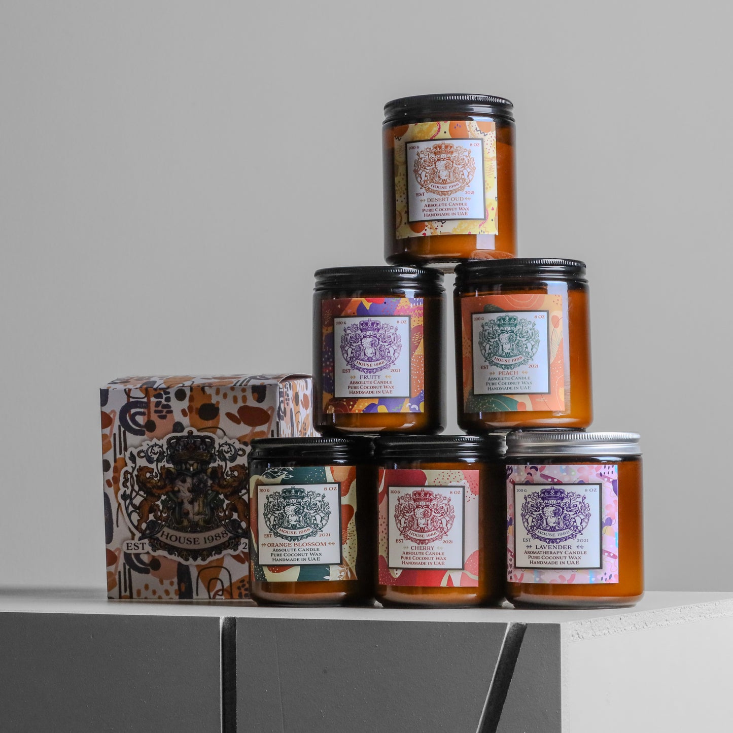 House 1988 candle gift set, pyramid of six amber jars with mixed lids and patterned labels