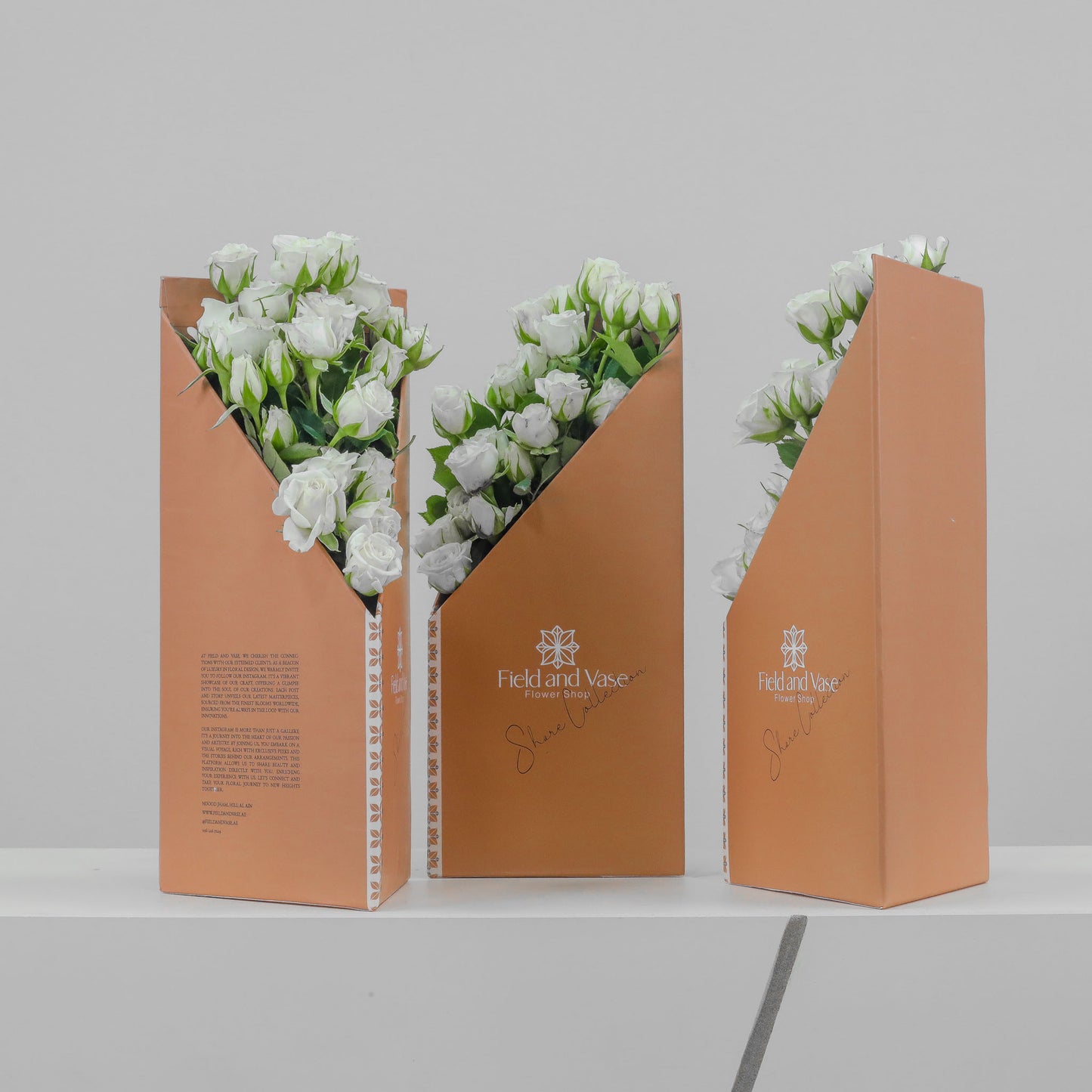 Medelya peach flower bag with V-notch front filled with white baby roses, free-standing design