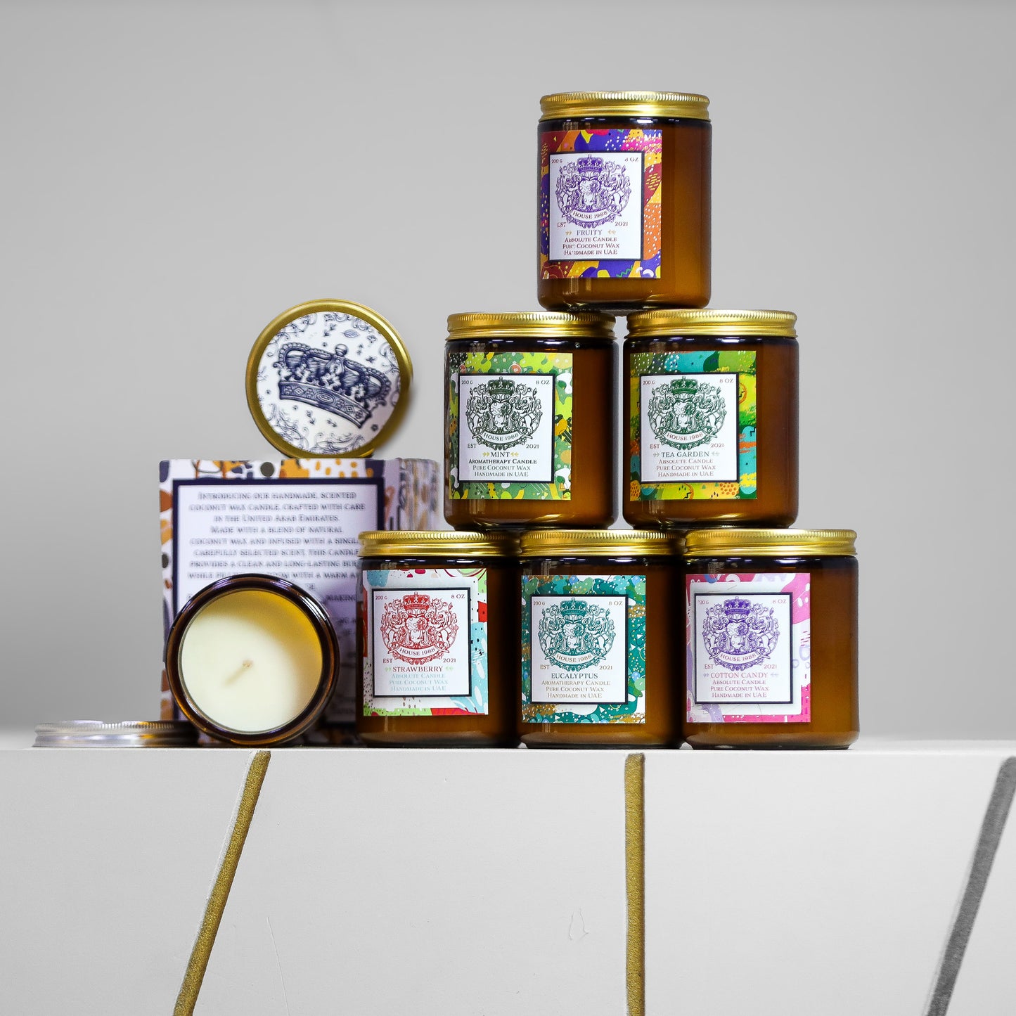 Pyramid of six House 1988 candles with gold lids, crown-print lid and open jar, assorted labels in amber glass jars